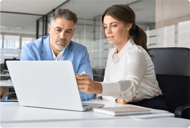 Two colleagues reviewing bookings on a laptop