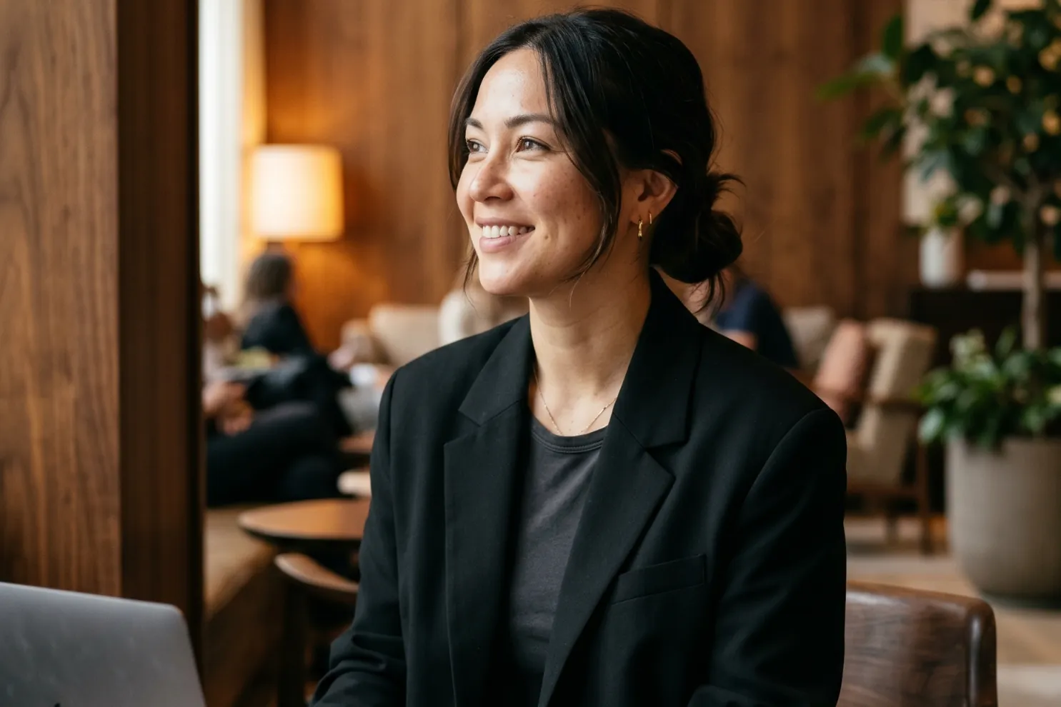 Hotellvärd som arbetar på en bärbar dator i en varm, träpanelad hotellounge