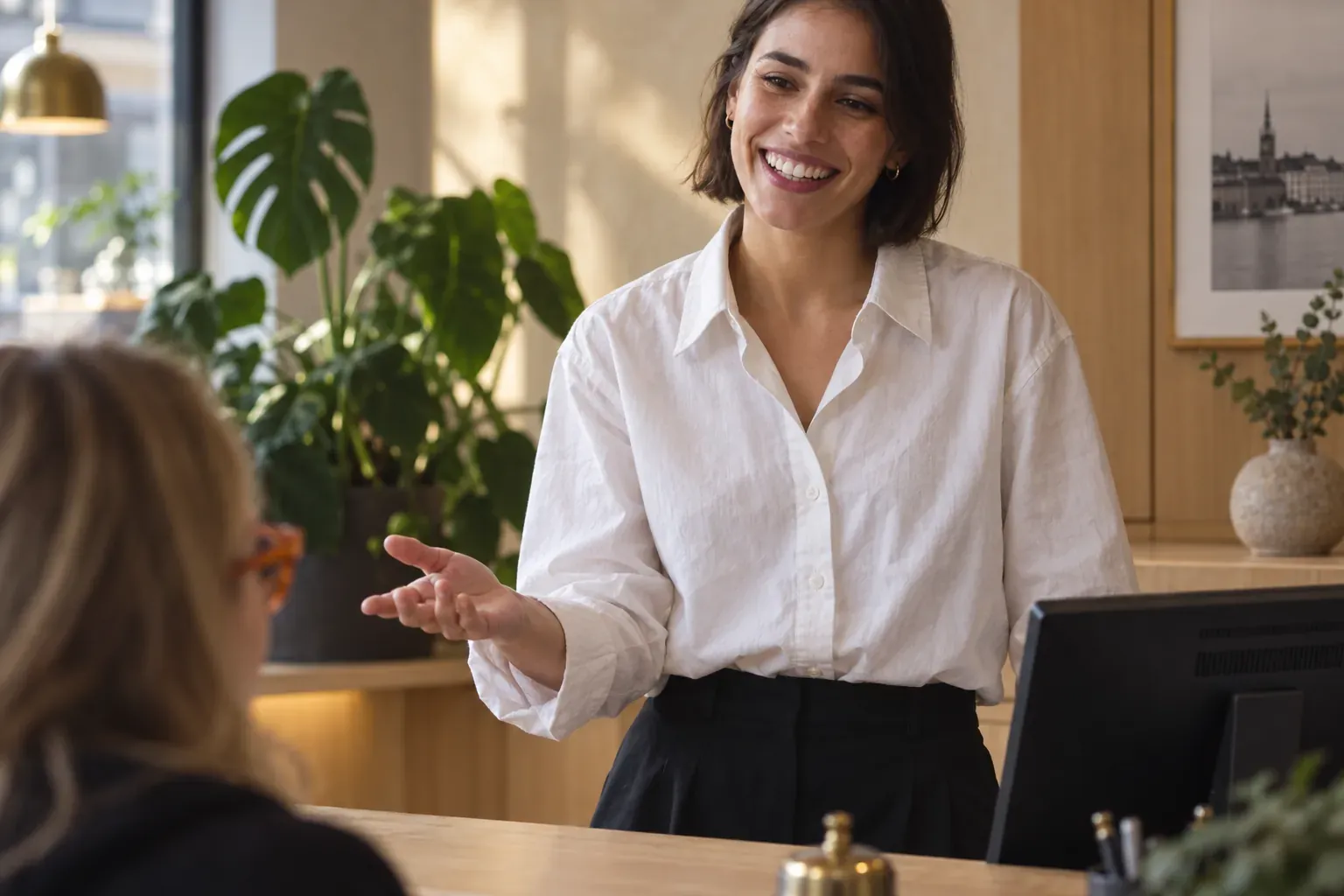 Värd som tar emot en gäst i receptionen på ett litet hotell