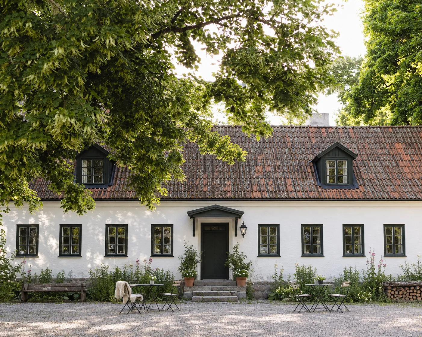 Maison d'hôtes en pierre calcaire blanche sous un grand arbre