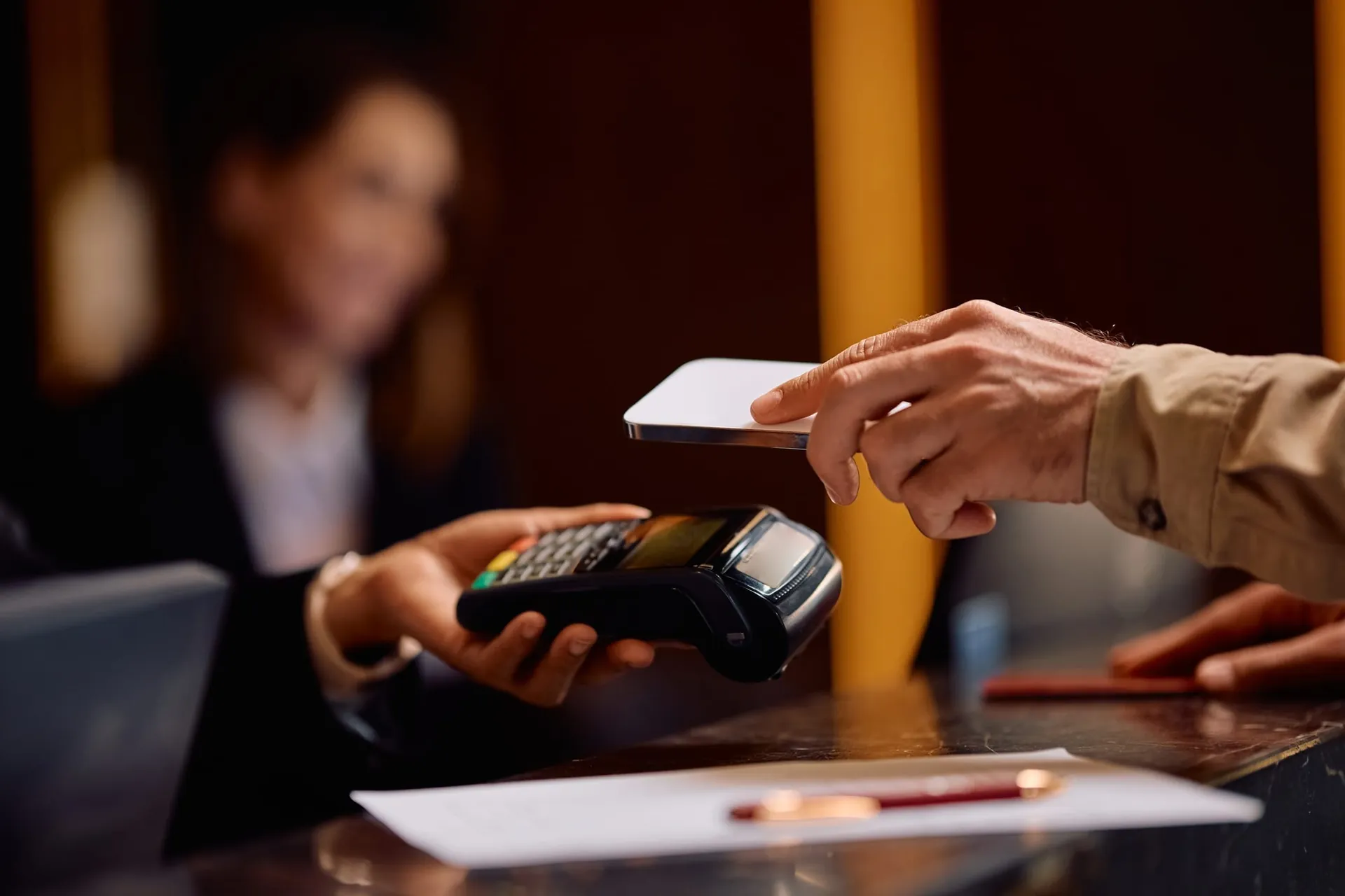 Huésped pagando en la recepción de un hotel